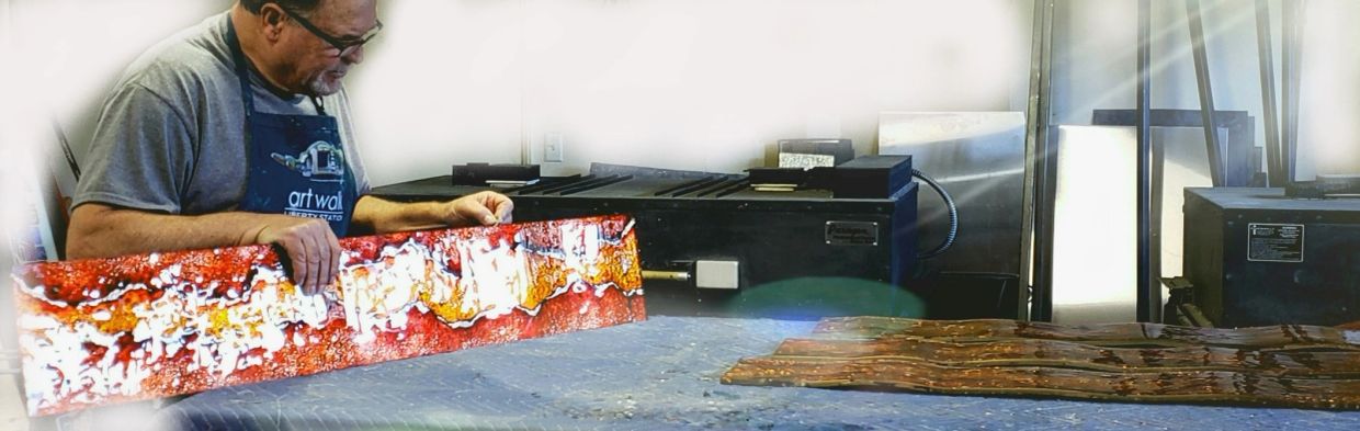 artist holding a glass artwork