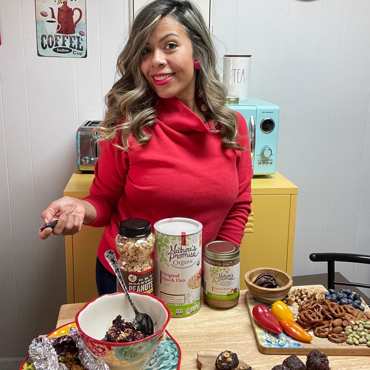 Woman in red shirt with healthy snacks and ingredients.