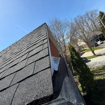 Close-up view of a house roof and gutter on a clear day.