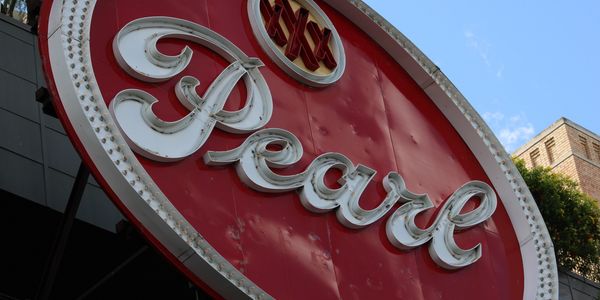 Large red sign with the word 'Peave' in white cursive letters.
