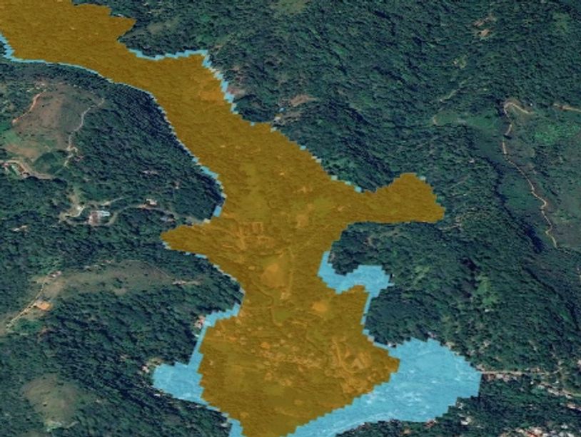 Aerial view of a forested area with water bodies highlighted in brown and blue.