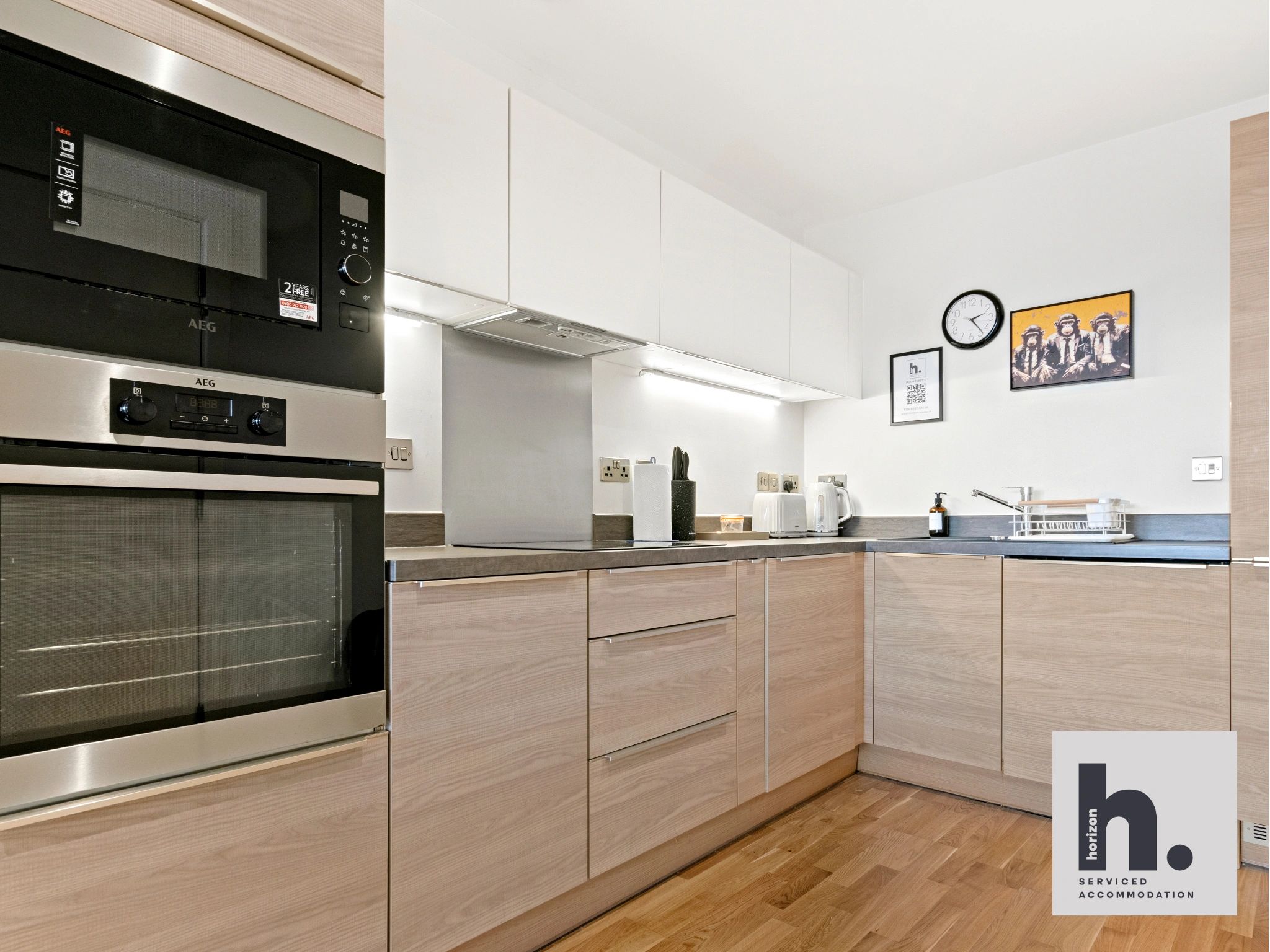 Modern kitchen with built-in oven, microwave, and wooden cabinets.