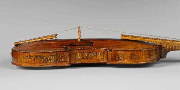Close-up of a violin with engraved words on its side.
