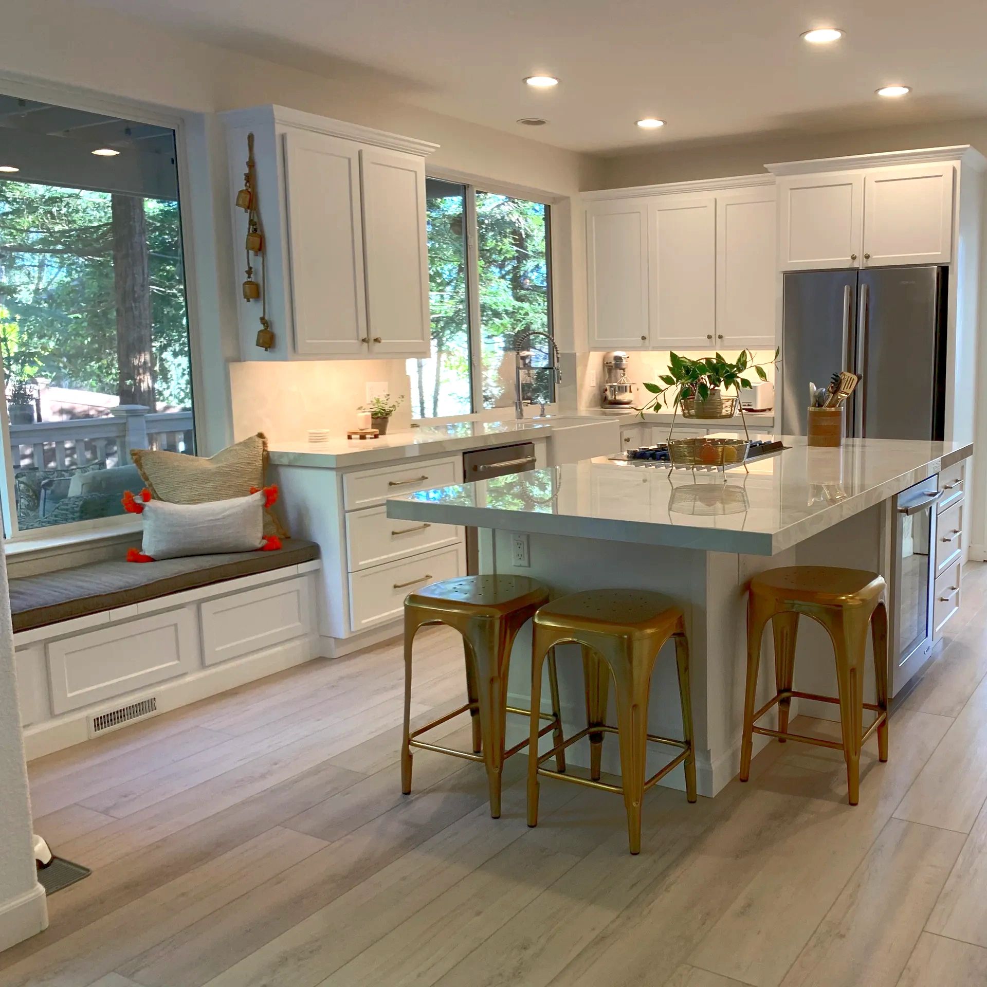 Bright modern kitchen with gold stools and large island.