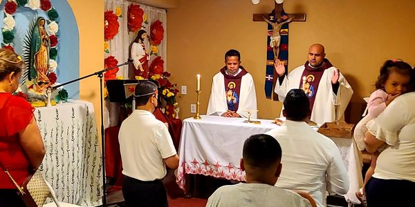 Priests conducting a religious service with attendees.