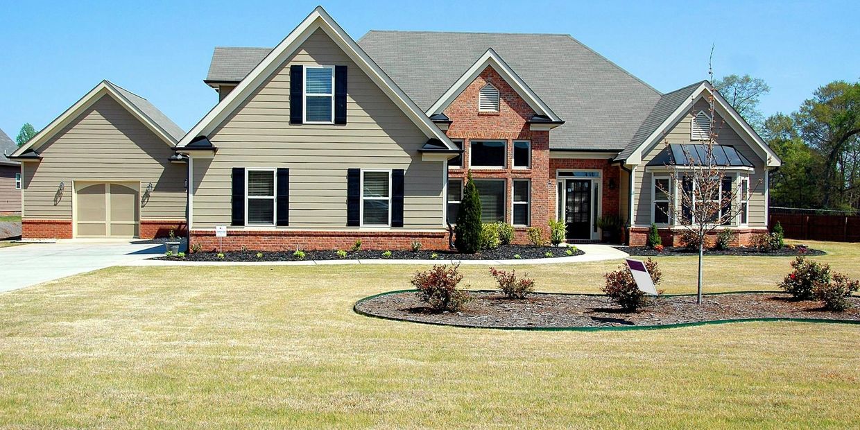 Large home featuring roofing, siding, and gutter services in Loganville, GA, with a clean lawn 