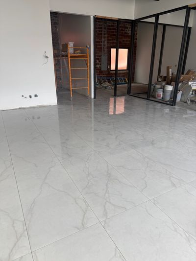 Newly installed glossy marble floor tiles in a modern interior under construction.