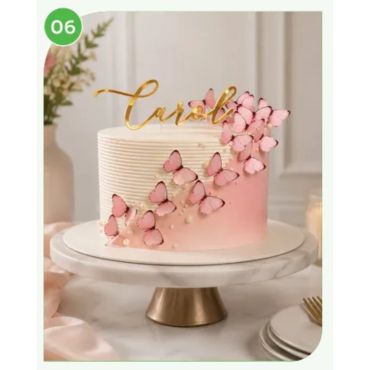 Elegant pink and white cake with butterfly decorations and gold topper.