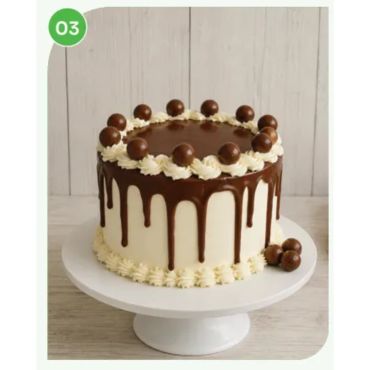 A chocolate drip cake with cream and chocolate balls on top.