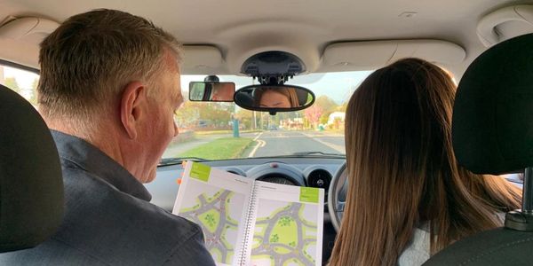 Driving instructor teaching student how to drive