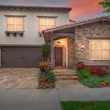 Cozy suburban house entrance at dusk with warm lighting.