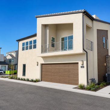 Modern beige two-story house with large garage and balcony.