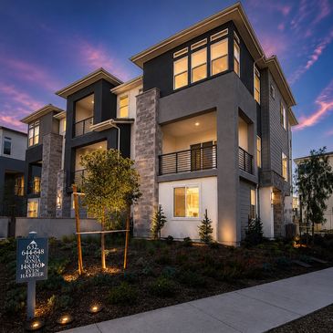 Modern three-story residential building at dusk.