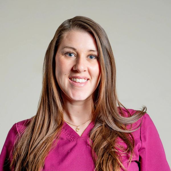 White Professional Female Smiling in Pink  Scrubs for a Portrait Photo