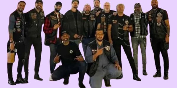 Group of men wearing matching biker vests posing together.