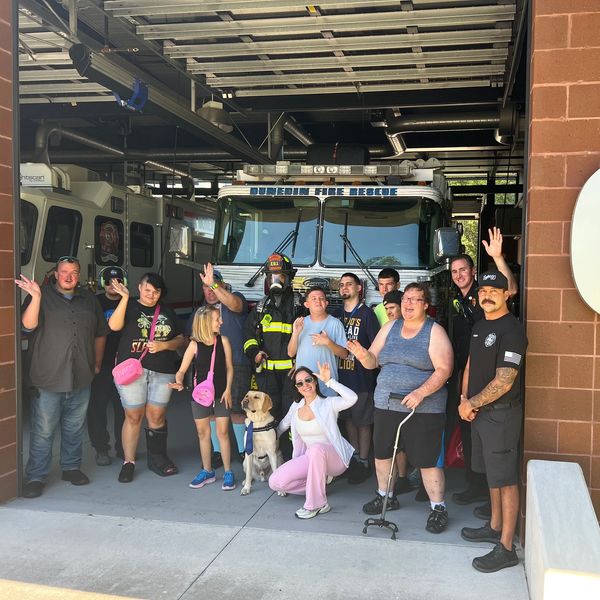 Group photo with fire rescue truck and dog.