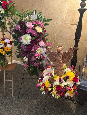 Elegant floral arrangements with a woven angel centerpiece in a cozy indoor setting.