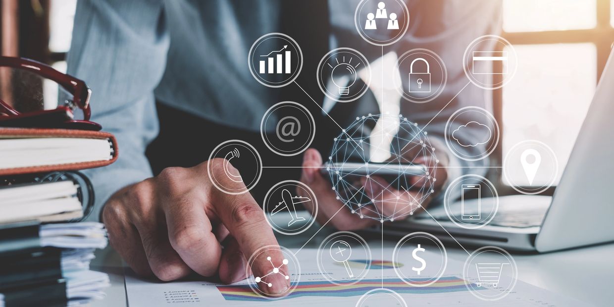 Businessman using smartphone and analyzing data with digital icons overlay.