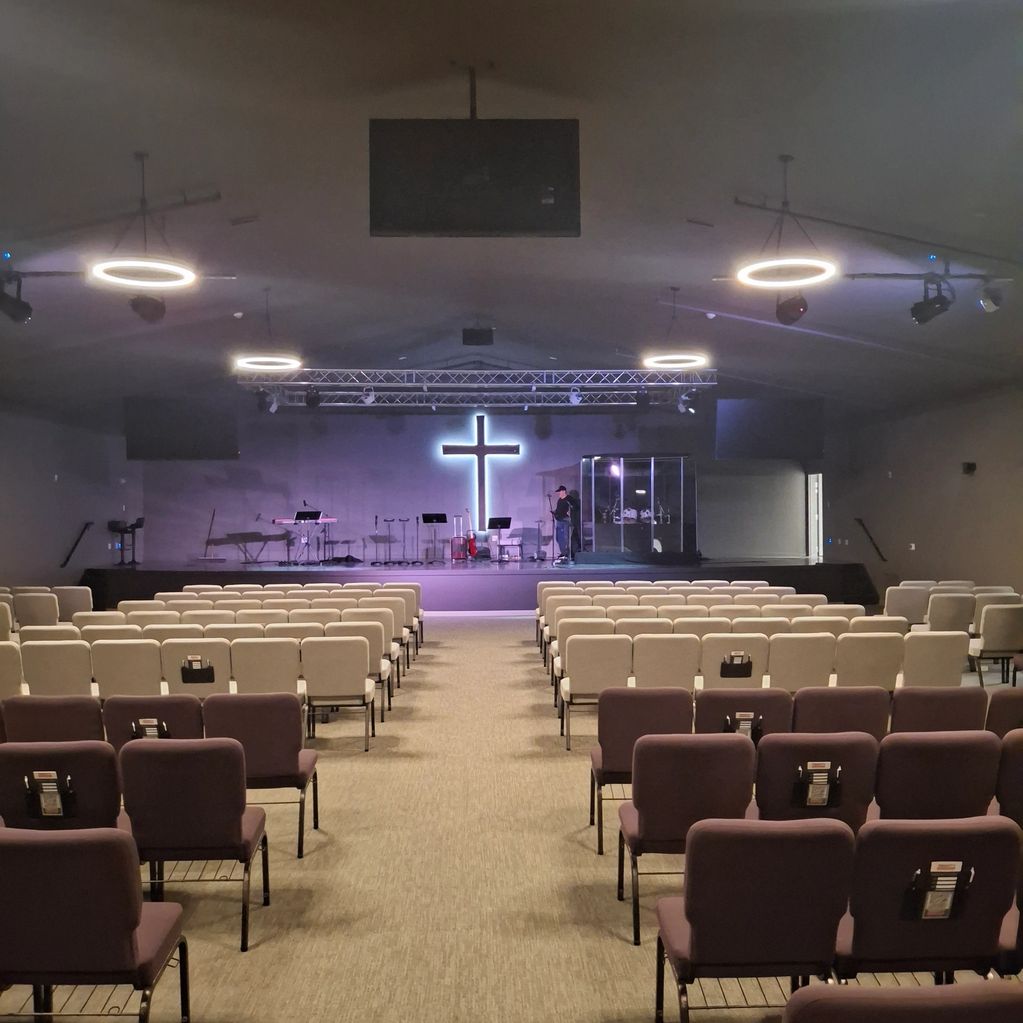 Modern church interior with illuminated cross and seating.