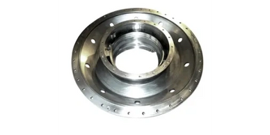 A shiny metallic circular mechanical part with multiple holes around its perimeter.