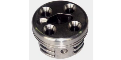Metal piston with four valve recesses and a triangular central cutout.