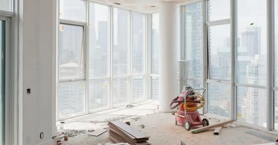 Empty high-rise apartment under renovation with floor-to-ceiling windows.