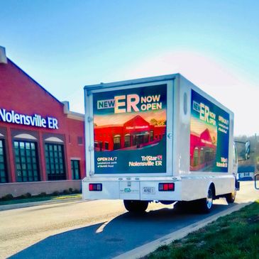 A truck with an advertisement for Nolensville ER on its sides and back.