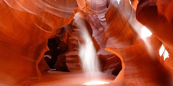 Sunlight beams shining through Antelope Canyon's red sandstone walls.