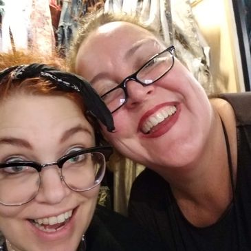 Two smiling women wearing glasses, posing closely for a selfie.