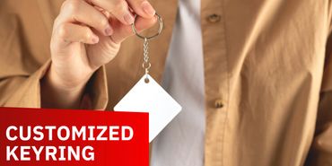 Person holding a blank customized keyring in hand.