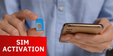 Person holding a SIM card and smartphone for activation.