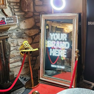 Interactive branded mirror booth with red carpet and props for corporate events.