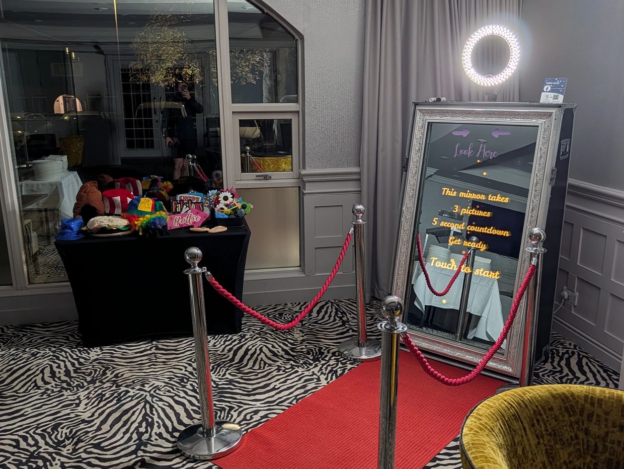 Interactive photo booth setup with props and a red carpet.