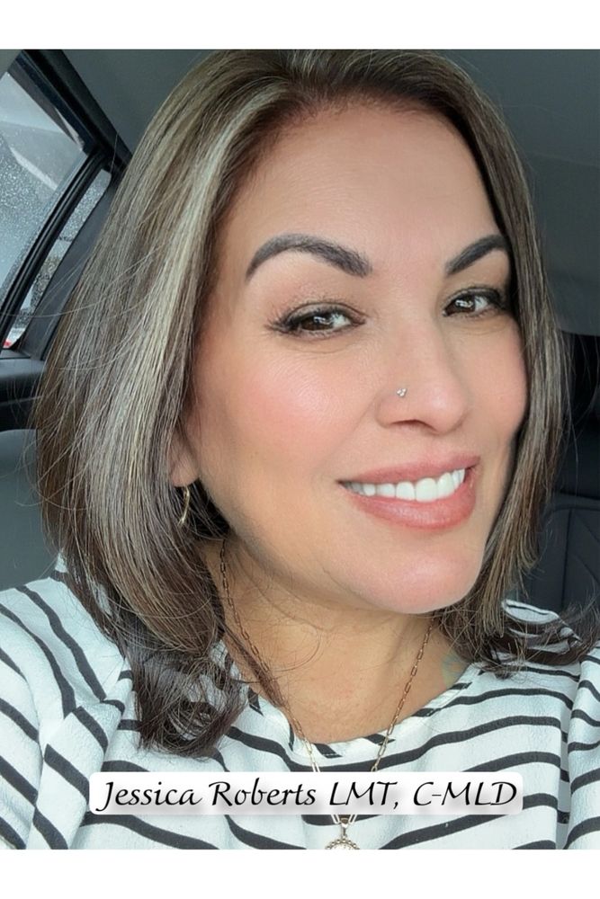 Smiling woman with striped shirt and nose piercing.