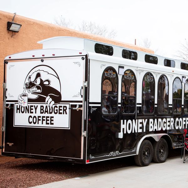 A black and white Honey Badger Coffee truck with a badger logo.