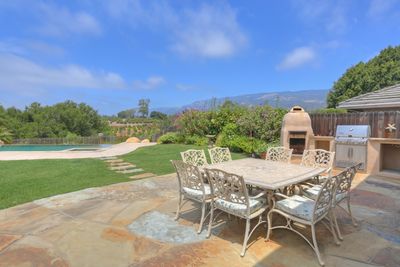 Backyard dining table with an exterior BBQ and firepit.