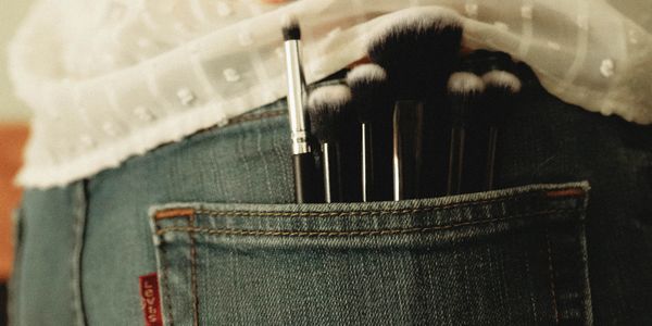 Makeup brushes in the back pocket of a makeup artist