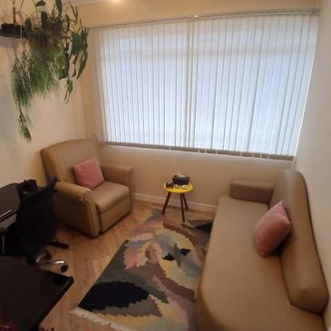 Cozy living room with beige furniture and pastel accents.