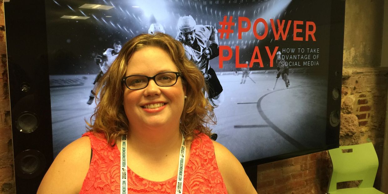 Woman smiling in front of a screen with #POWER PLAY message.
