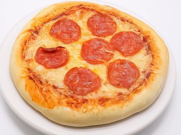 A pepperoni pizza with cheese on a white plate.