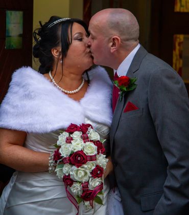 Bride and groom romantically kissing.