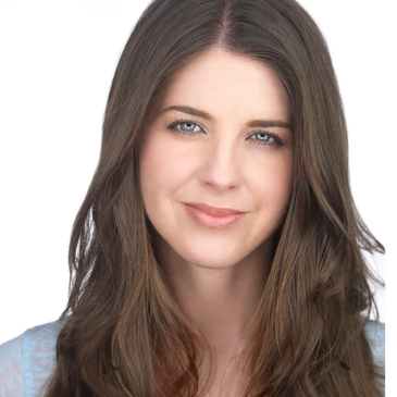 Close-up portrait of a smiling woman with long brown hair and blue eyes.