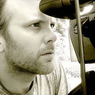 Close-up profile of a man intently looking at a camera or equipment.