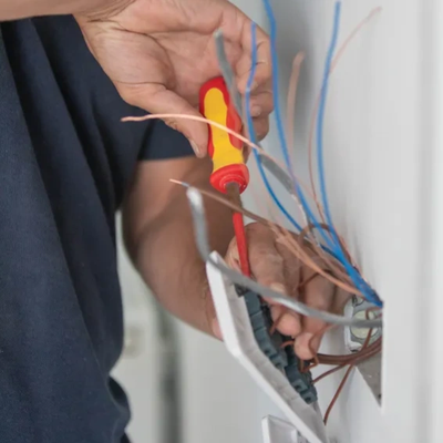 Person repairing electrical wiring with a screwdriver.