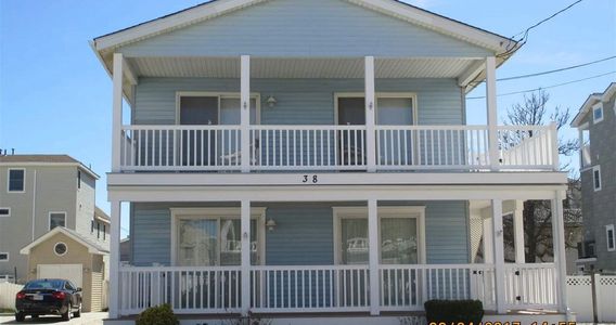 Front of house showing the second floor unit with a covered deck.