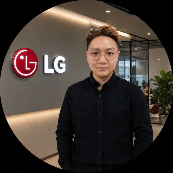Man in black shirt standing by LG logo in modern office.