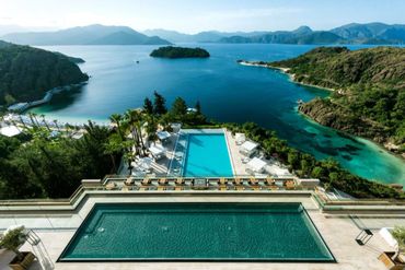 Luxury resort pools overlooking a scenic tropical bay with islands and mountains.