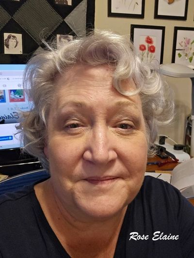Portrait of an elderly woman with curly gray hair and a gentle smile.