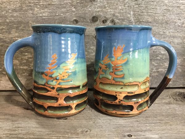 A pair of carved tree mugs.