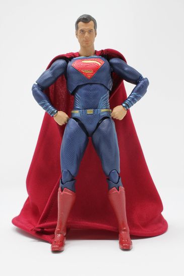 Superman toy with red shoes on white background.